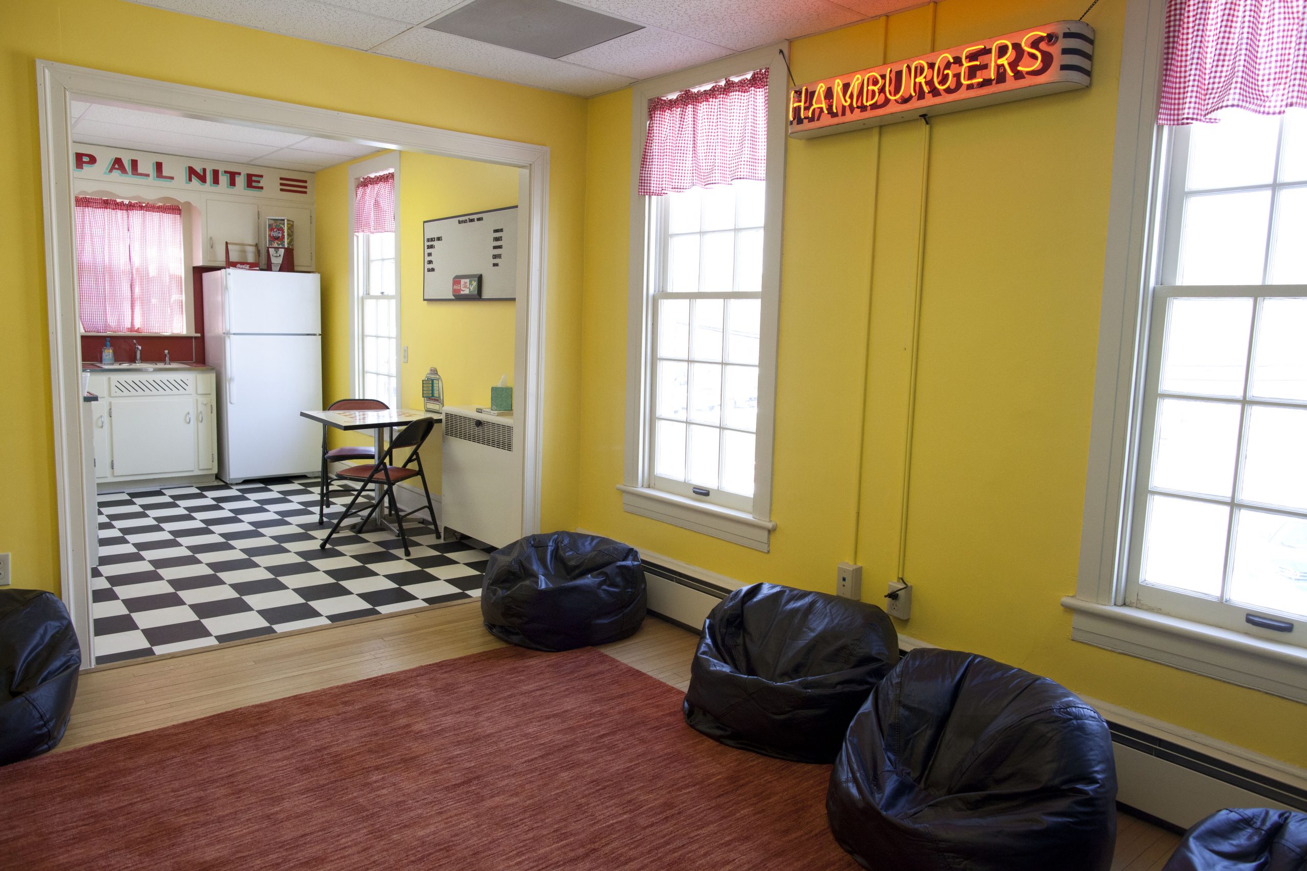 Designed to embrace the needs of grieving teens who are often up all hours of the night doing their grief work, we created a 24-hour diner themed room just for them!  “A local hotspot, “The Tropical Treat” donated the hamburger sign hanging in the window to help them realize that junk food can be an essential coping tool for a grieving teen. The kitchen, complete with a coffee bar and refrigerator full of soda and snacks, sets the stage for their grief work. The Teen Suite was lovingly gifted by the Don Smith Family.”
