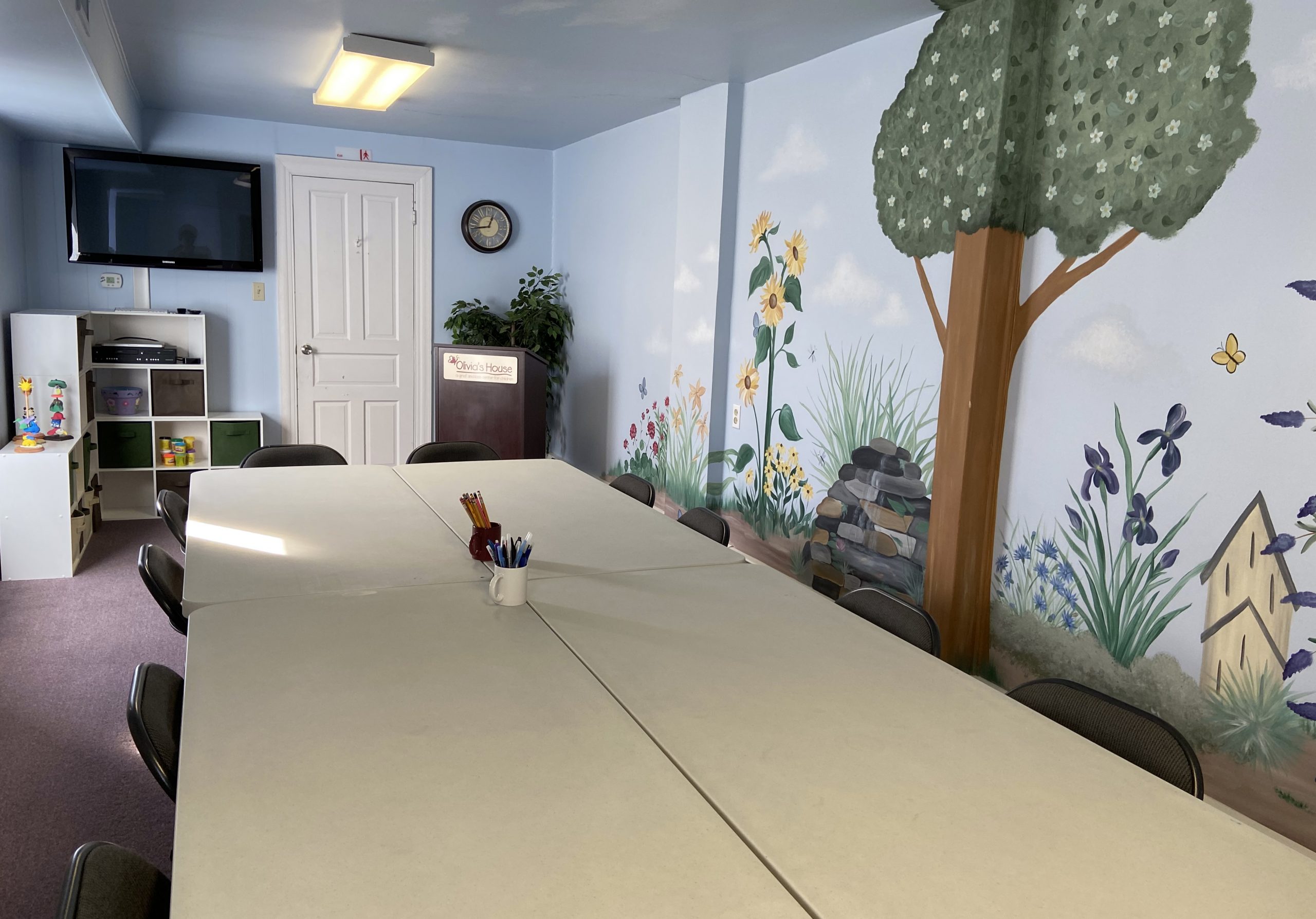 The Multipurpose Room A big space, this room serves Olivia's House in many ways. It functions as our "teen art area" and also as a training facility for grief workshops. We hold board meetings as well as events in this space when necessary. The furniture can easily be removed to provide a play space during programs too, should the need arise!